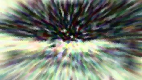 Abstrakte Komposition aus bunten, unscharfen Streifen, die von einem dunklen Zentrum am oberen Bildrand radial nach außen laufen; unten hellt das Bild auf.