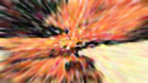 Abstraktes Bild mit radialer Zoom-Unschärfe: orange, rote und gelbe Streifen strahlen von einer dunklen Mitte nach außen, dazwischen grüne und schwarze Pixelflecken.