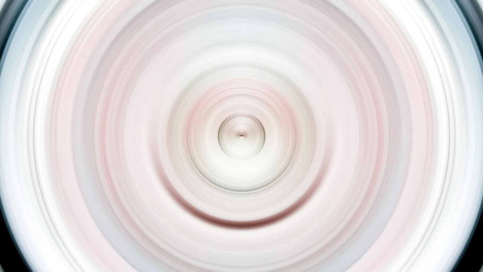 Konzentrische, weich verwischte Kreise in Rosa, Weiß und Grau, die von einem hellen Zentrum nach außen laufen.