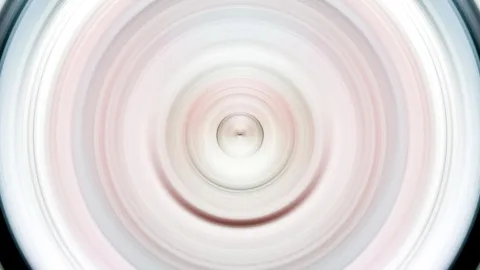 Konzentrische, weich verwischte Kreise in Rosa, Weiß und Grau, die von einem hellen Zentrum nach außen laufen.