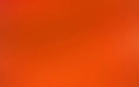 Fast vollflächiger Farbverlauf von tiefem Rot oben links zu leuchtendem Orange unten rechts, mit einem helleren Lichtfleck am rechten Rand.