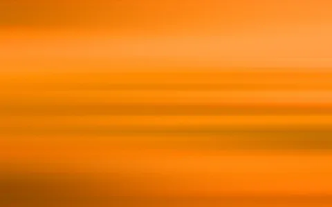 Abstrakte, horizontal verwischte Streifen in Orange- und Gelbtönen, von hell oben bis dunkler unten.